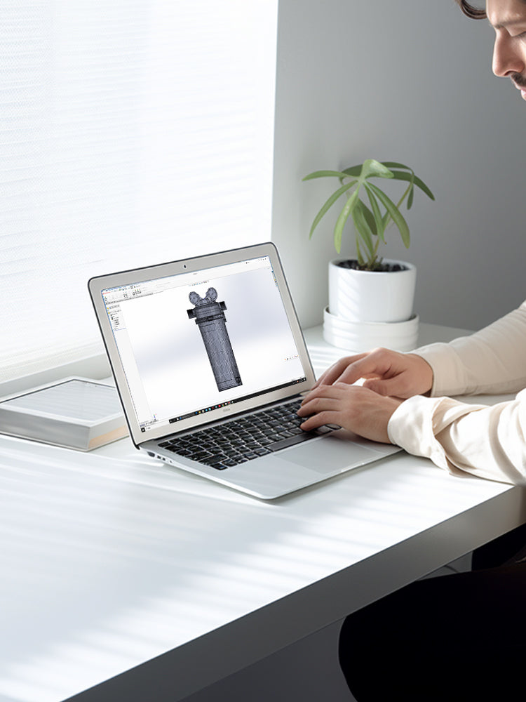 Person using a laptop to design whole house water filter at a desk.