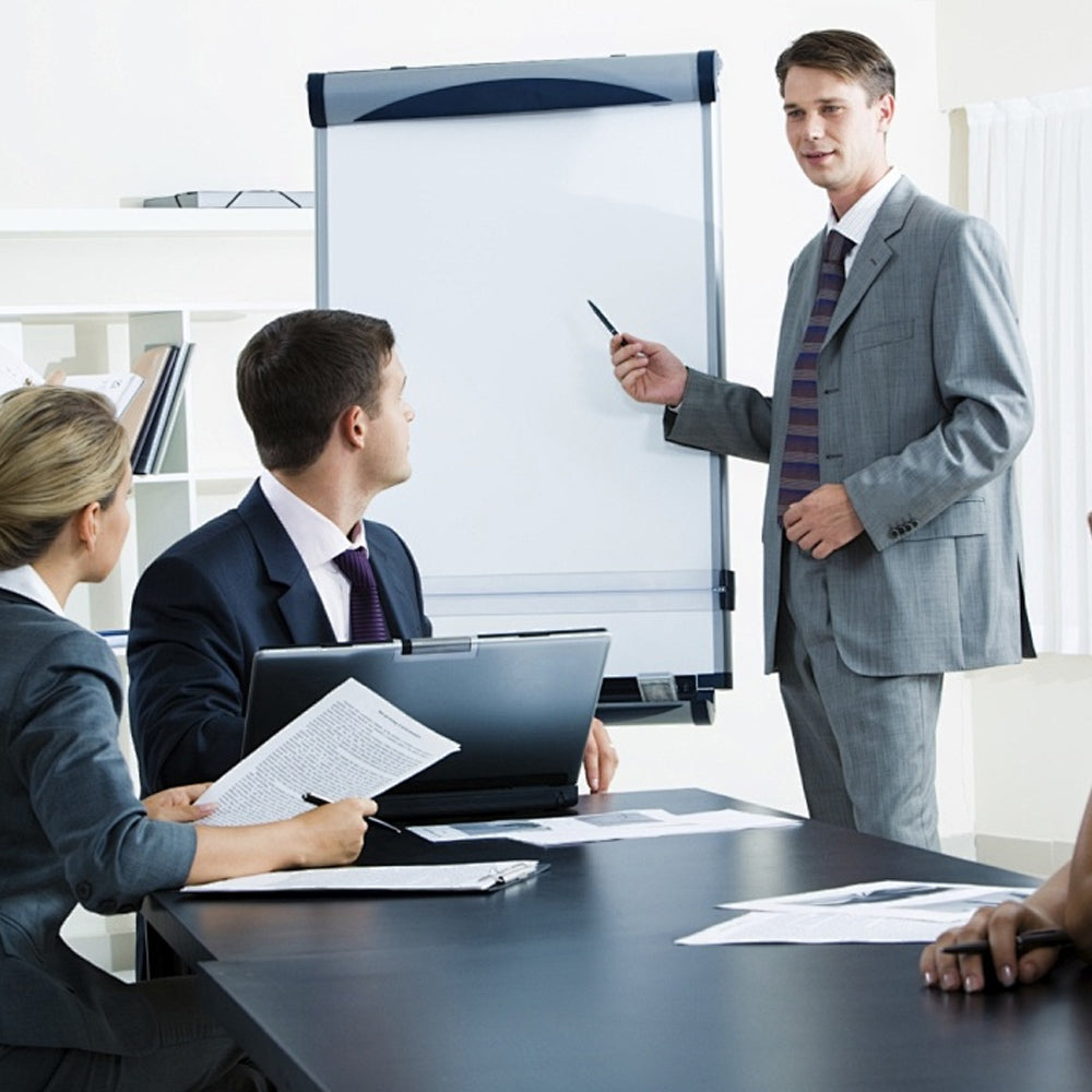 Business meeting with a presenter in front of a whiteboard